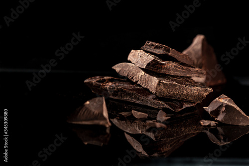 broken bar of dark chocolate on a dark background