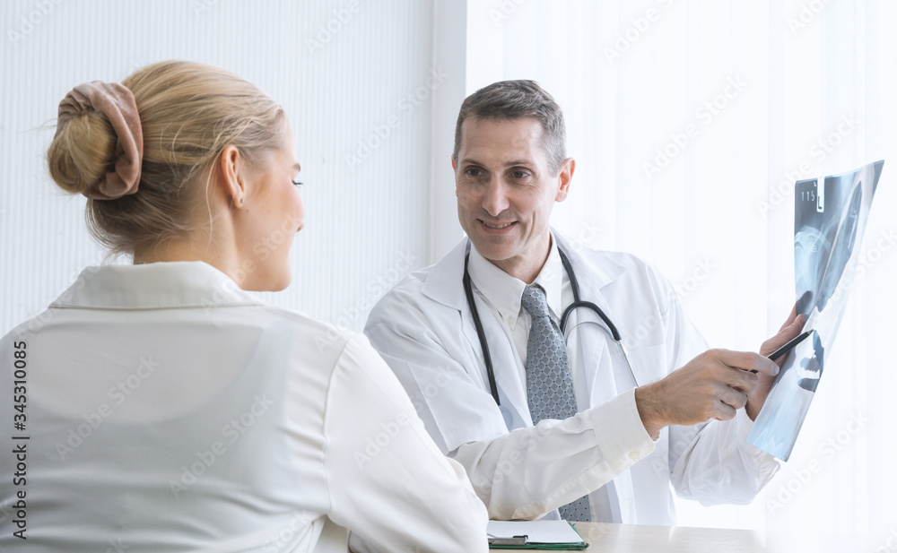 © metha275 - Doctor talking and diagnostic with his patient and holding x ray film in examination room at the hospital. Health concept
