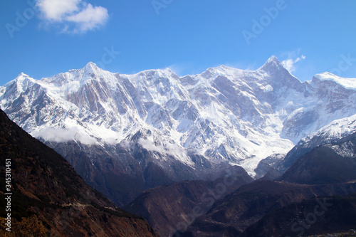 Nanga Bawa Peak, snowy mountains, blue sky, white clouds, folk houses and wild peach blossoms in the mountains! © TOM.zzl
