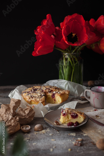 Still life with red tulips and a cherry pie. tasty and healthy food, homemade cakes