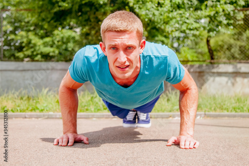 Sport, health and lifestyle concept. Portrait of muscular young man during his workout on the street. Horizontal image.