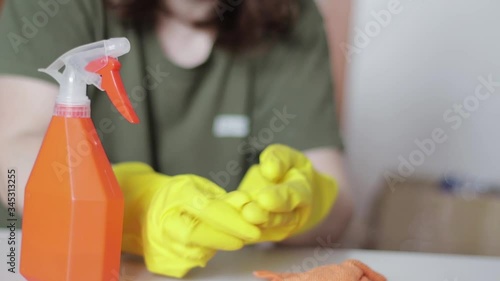 The woman finished disinfecting activities at home, removes rubber gloves and a protective mask. House disinfection