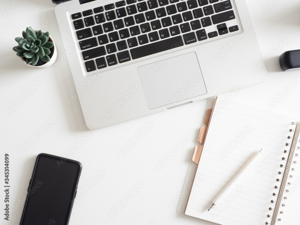 top view of office desk table with notebook, laptop, plastic plant, smartphone on white background, graphic designer, Creative Designer concept. top view of office desk table with notebook, laptop, plastic plant, smartphone on white background, graphic designer, Creative Designer concept.