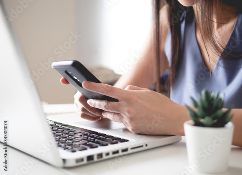 work from home concept with woman working on Smart Phone and laptop computer.