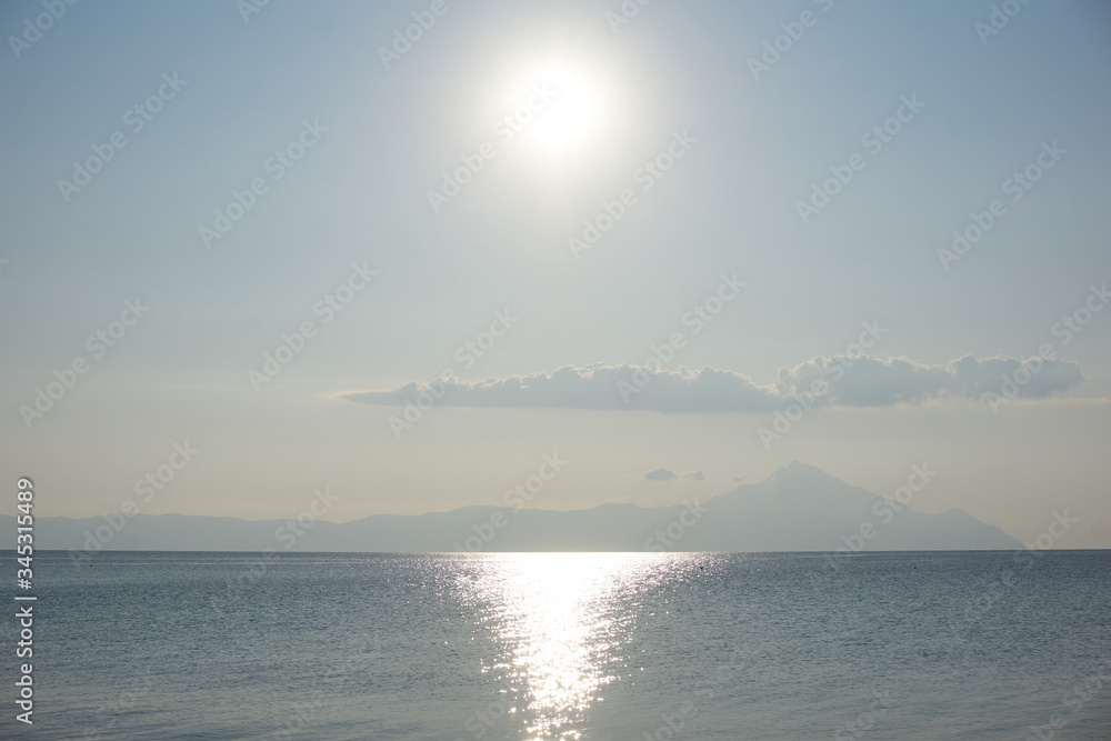 Sunny sea view with clouds and mountains in the bckground
