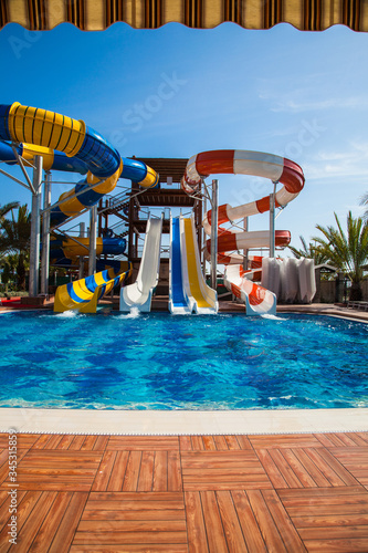 Colorful waterpark tubes and pool in tropical aquapark
