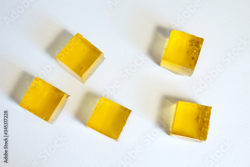 Yellow jelly cubes on a white background