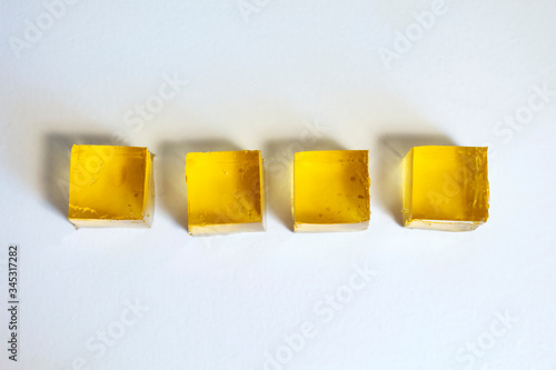 Yellow jelly cubes on a white background