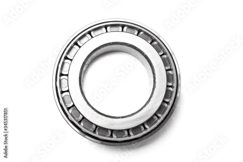 Single row tapered roller bearing made of shiny metal is designed to absorb radial and one-sided axial loads of a vehicle. Spare part for sale or repair in a workshop or car service.