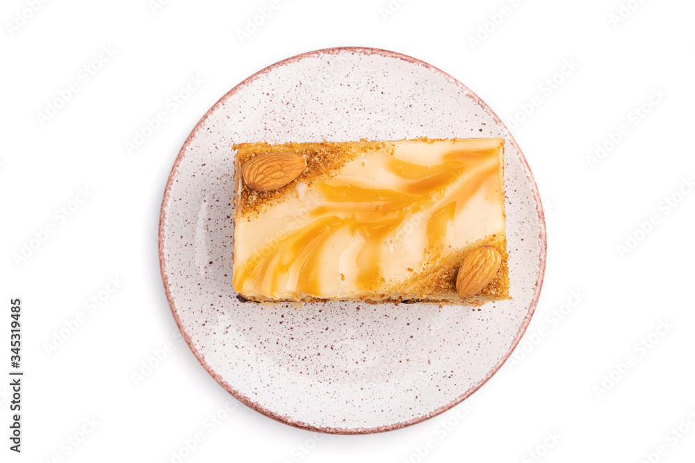 Honey cake with milk cream, caramel, almonds isolated on a white background. Top view.