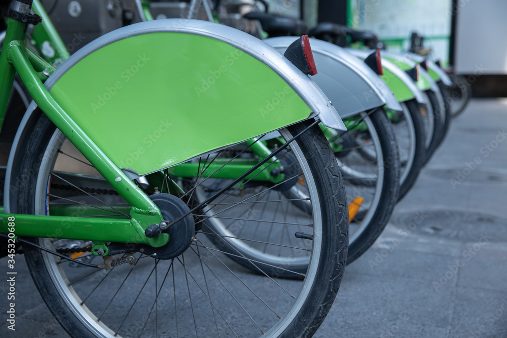 close up view group of green bicycle wheels to rent out for free at parking station. close up view group of green bicycle wheels to rent out for free at parking station.
