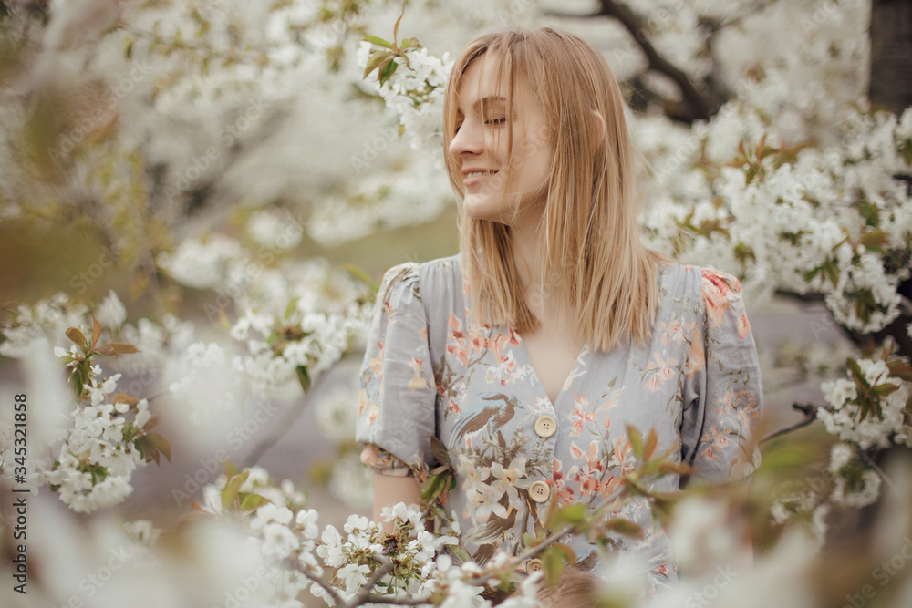 Beautiful girl in a flowering garden. Cherry garden. Summertime Concepts. Closeup Portrait of Positive. happy young woman enjoying smell in a flowering spring garden Beautiful girl in a flowering garden. Cherry garden. Summertime Concepts. Closeup Portrait of Positive. happy young woman enjoying smell in a flowering spring garden