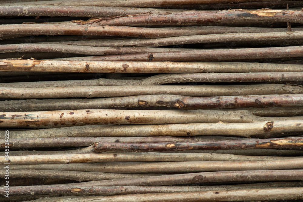 Fence of horizontal thin trunks of young trees. Natural background