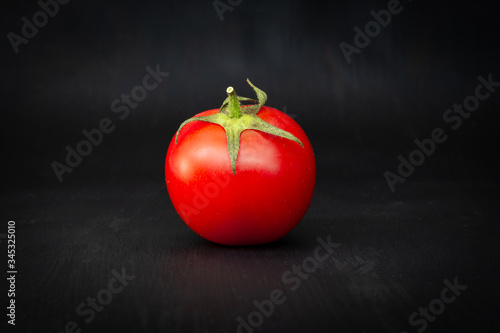 Red cherry tomato isolated on black