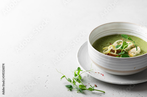 vegetarian cream soup of green vegetables on a light background, place for text