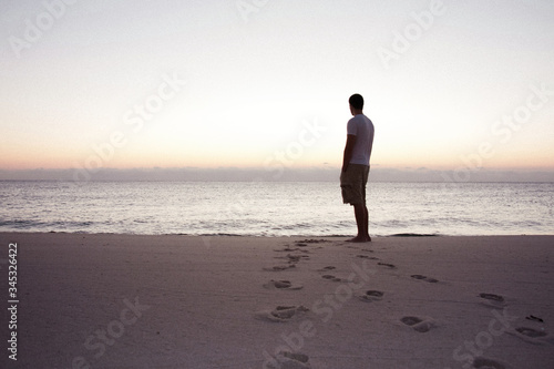 Man standing near the beach with his back to the camera