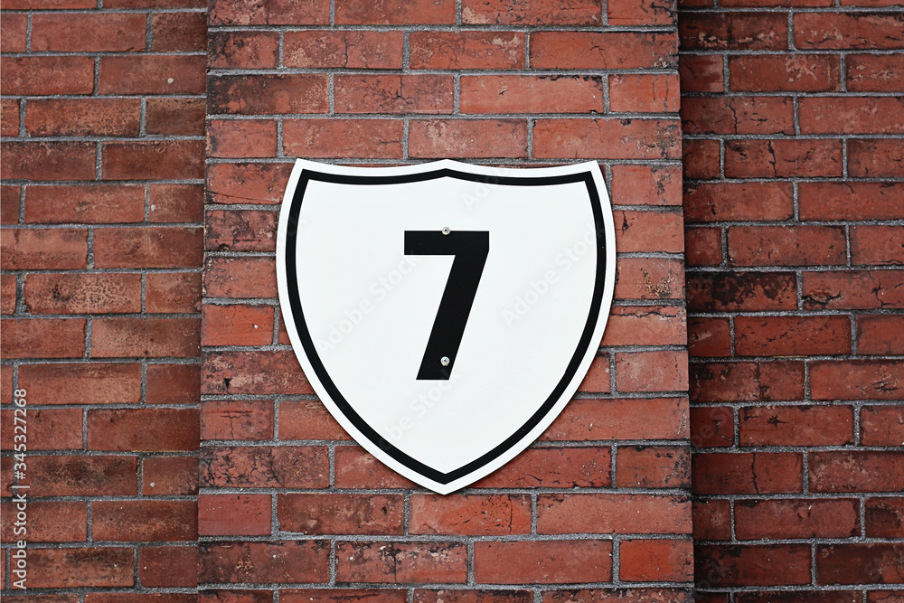 Red brick wall with the number seven on it. Red brick wall with the number seven on it.