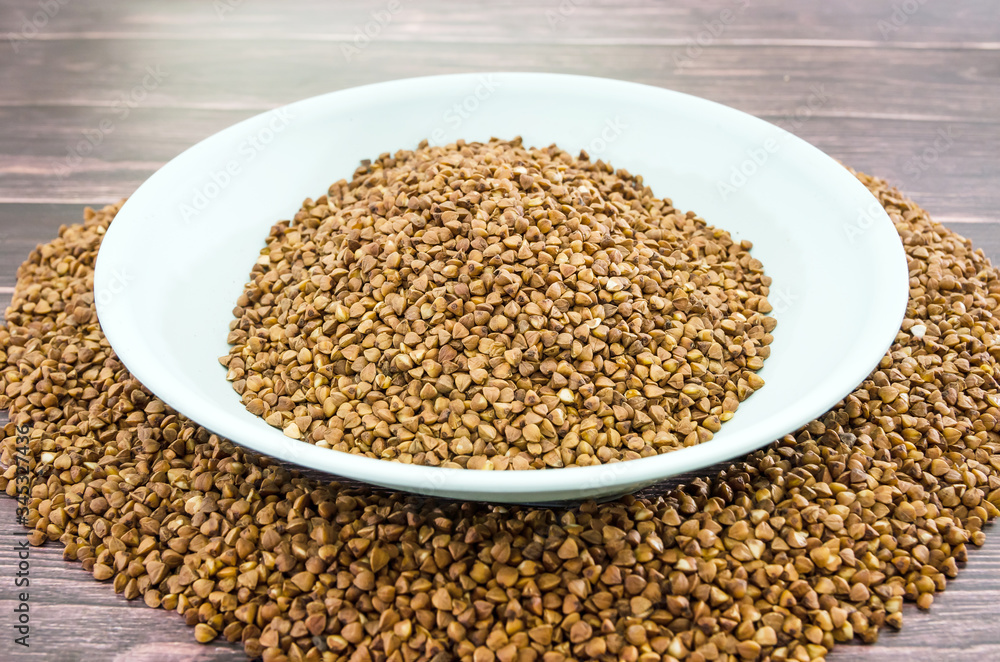 buckwheat in a plate on a wooden background. buckwheat in a plate on a wooden background.