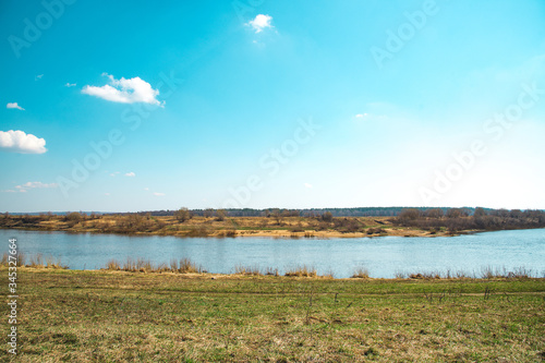 Spring landscape with blue sky, river and meadow © lusyaya