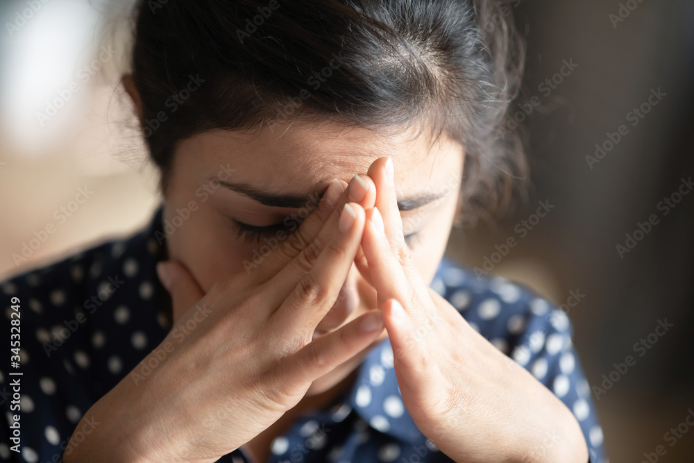 Close up head shot depressed young indian woman feeling exhausted. Stressed tired unhealthy millennial hindu student girl touching forehead, suffering from overwork, panic attack, need break time Close up head shot depressed young indian woman feeling exhausted. Stressed tired unhealthy millennial hindu student girl touching forehead, suffering from overwork, panic attack, need break time
