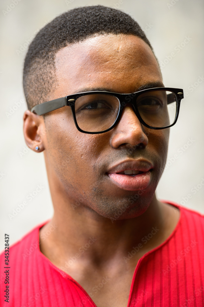 Face of young handsome African man with eyeglasses