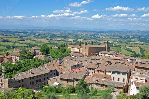 Imagen aérea de un pequeño pueblo de la Toscana en Italia, día soleado con el cielo salpidado de nubes