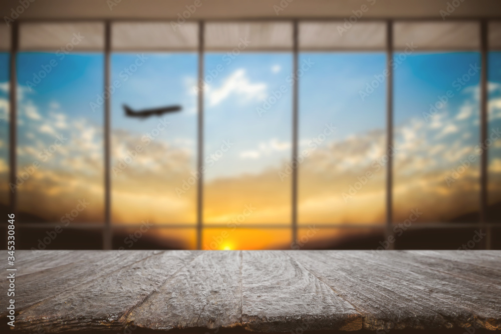Fototapeta premium Empty wooden desk space and blurry background of airport for product display montage.