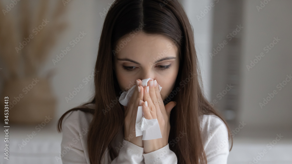 Close up of sick millennial Caucasian girl blow nose use paper tissue napkin suffer from flu on cold at home, ill young woman feel unhealthy unwell, coughing sneezing having influenza or grippe Close up of sick millennial Caucasian girl blow nose use paper tissue napkin suffer from flu on cold at home, ill young woman feel unhealthy unwell, coughing sneezing having influenza or grippe