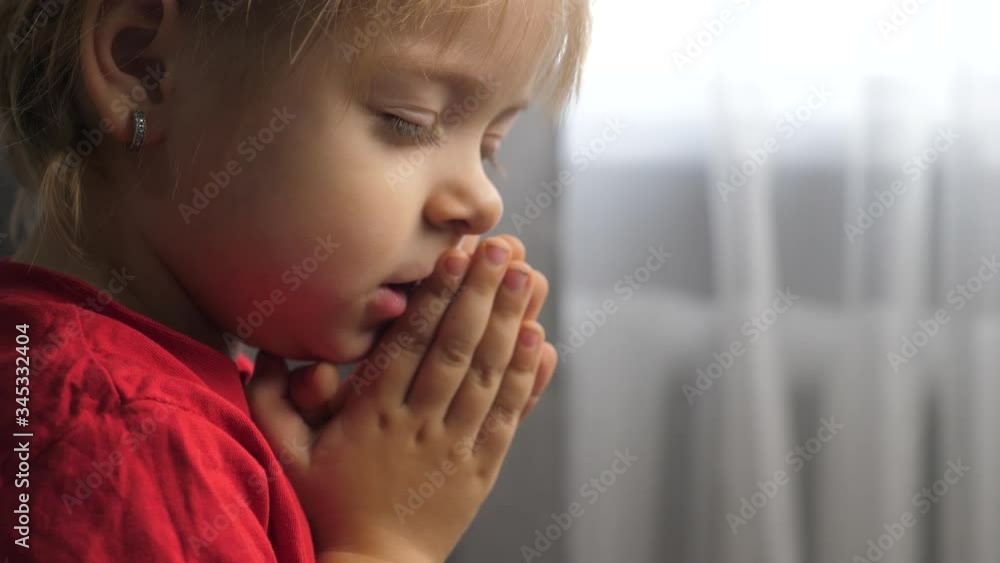 little daughter girl lifestyle makes a wish prayers bedtime religion concept . prayer child indoors praying by bed in front of window little daughter girl lifestyle makes a wish prayers bedtime religion concept . prayer child indoors praying by bed in front of window