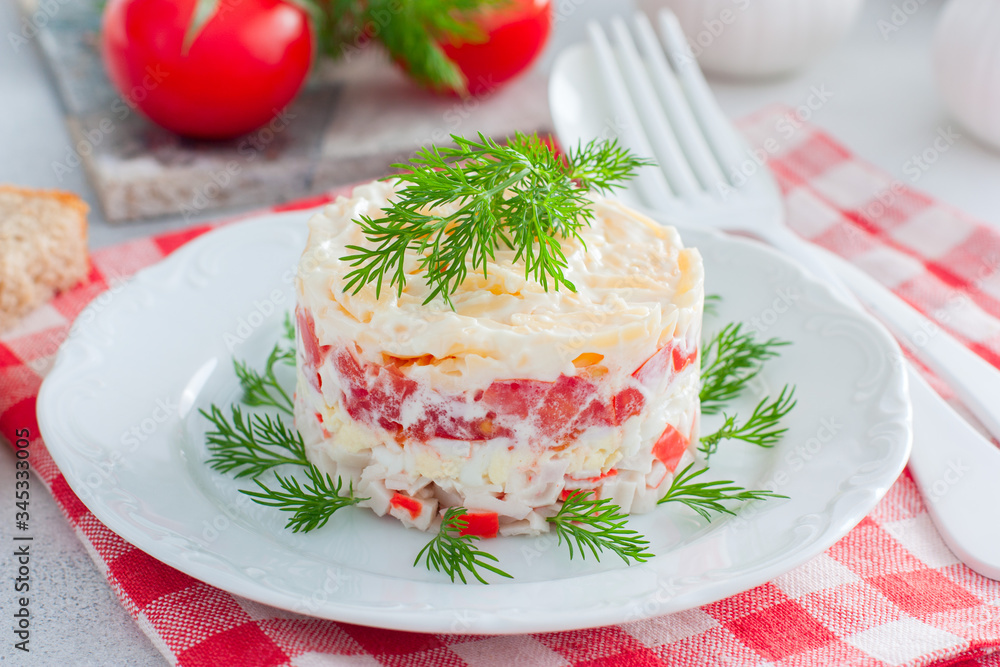 Homemade salad with crab sticks, tomatoes, cheese on a white dish, horizontal