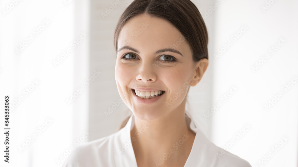 Portrait of smiling young Caucasian woman with healthy glowing soft facial skin pose in bathrobe, happy millennial female show white teeth, follow good dental oral care, skincare, beauty, spa concept Portrait of smiling young Caucasian woman with healthy glowing soft facial skin pose in bathrobe, happy millennial female show white teeth, follow good dental oral care, skincare, beauty, spa concept