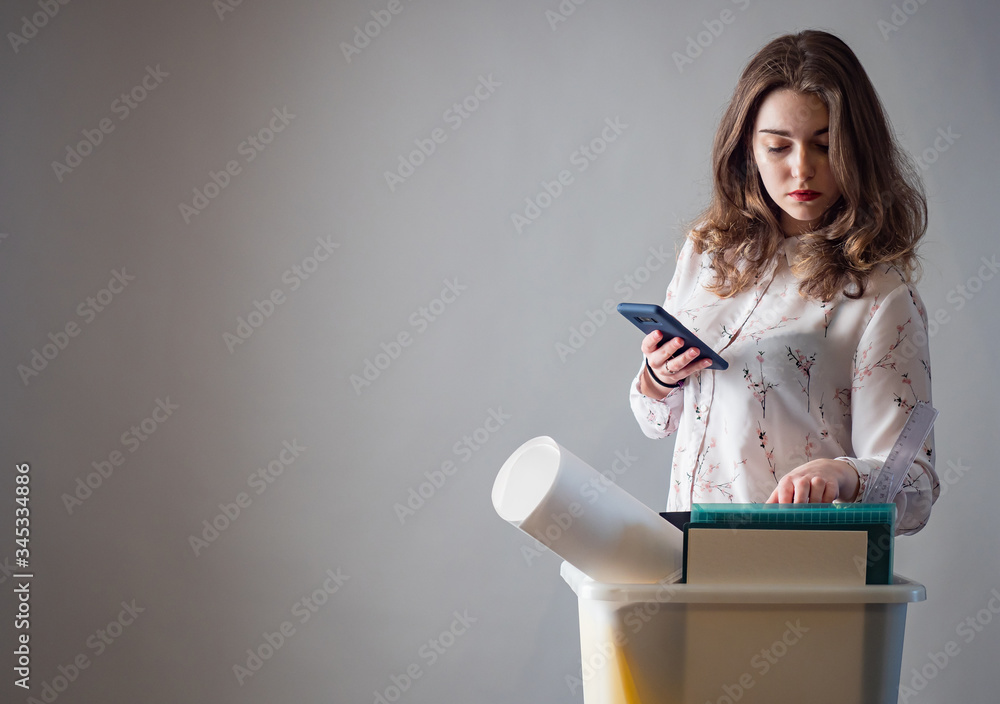 Fototapeta premium Job loss. A girl who got fired from her job. Loss of jobs. The girl is sad because of the dismissal. Unemployment.