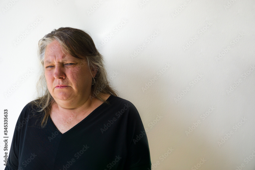 Angry old woman squints her green eyes. One beautfiul green eyed elder woman with anger concept. Modern mad blonde hair lady isolated on white wall background. Angry old woman squints her green eyes. One beautfiul green eyed elder woman with anger concept. Modern mad blonde hair lady isolated on white wall background.