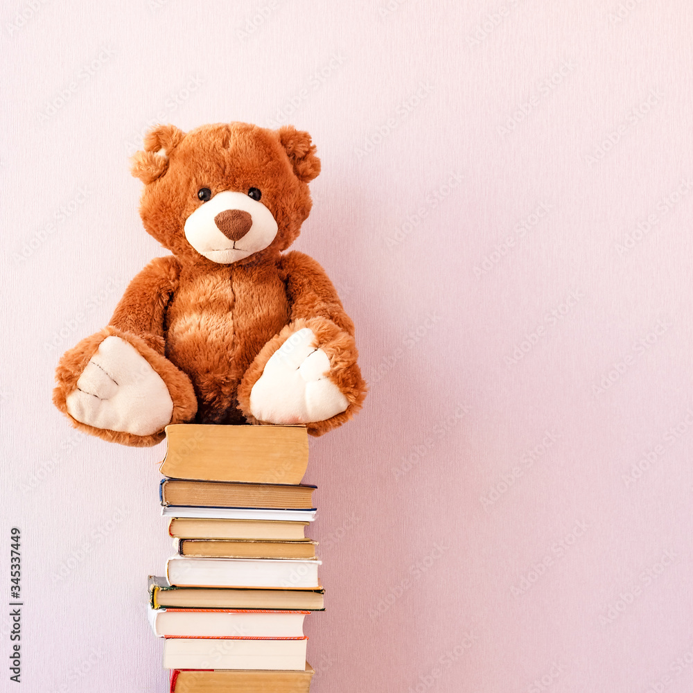 Soft stuffed toy Teddy bear sits on a stack of books. Education concept, back to school, reading speed Soft stuffed toy Teddy bear sits on a stack of books. Education concept, back to school, reading speed