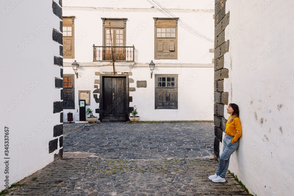 Traveller woman with the old architecture of city of Teguise in Lanzarote Traveller woman with the old architecture of city of Teguise in Lanzarote