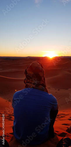 man watching the sunset in the desert