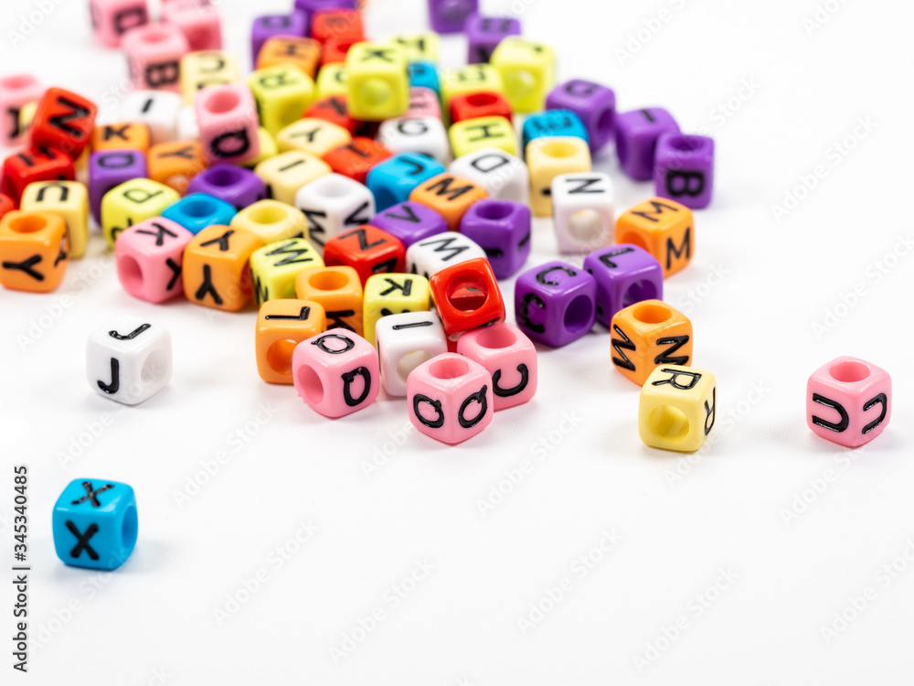 Colorful alphabets beads on white background, selective focus.  concept image