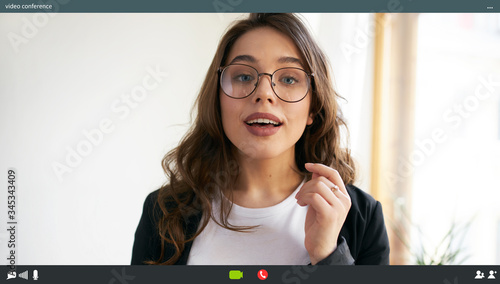 Foto Indoor shot of energetic attractive young female manager in eyeglasses talking t