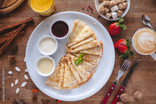 thin pancakes with jam honey and sour cream and coffee