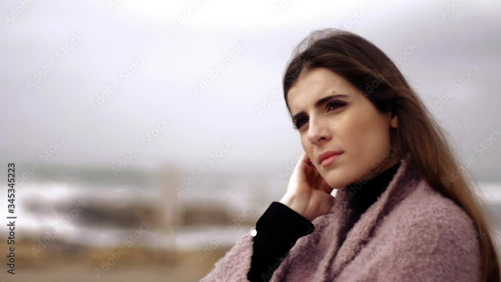 Woman alone during quarantine for coronavirus in front of the ocean thinking sad about her love Woman alone during quarantine for coronavirus in front of the ocean thinking sad about her love