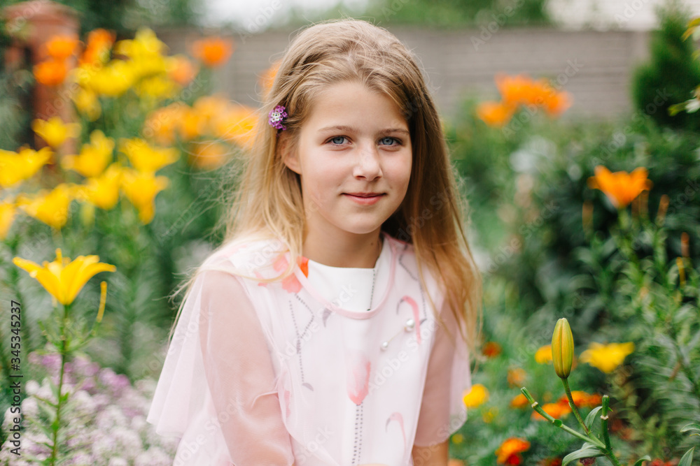beautiful blue-eyed girl with long blond hair. little girl in a pink flamingo dress. girl in the flower garden. summer bright, emotional photo. large, thick, bright flower garden near the house. beautiful blue-eyed girl with long blond hair. little girl in a pink flamingo dress. girl in the flower garden. summer bright, emotional photo. large, thick, bright flower garden near the house.