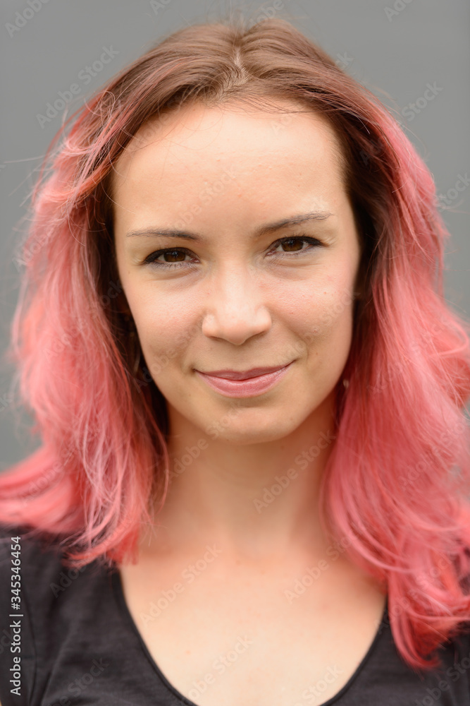 Fototapeta premium Face of beautiful woman with pink hair against gray wall