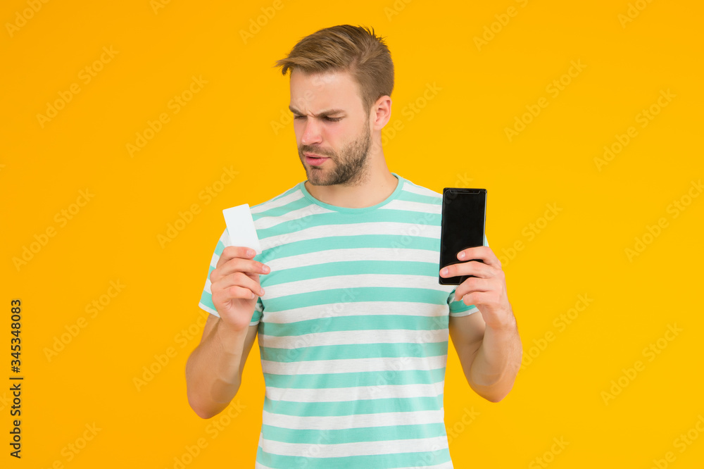 Shopping discount card. Handsome guy hold card and phone. Gift card or voucher. Cash coupon. Mobile shopping and commerce. Save money on every purchase with credit card, copy space Shopping discount card. Handsome guy hold card and phone. Gift card or voucher. Cash coupon. Mobile shopping and commerce. Save money on every purchase with credit card, copy space