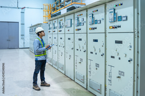 Engineer working and check status switchgear electrical energy distribution at substation room, maintenance engineers inspect relay protection system electric concept, Medium voltage switchgear photo