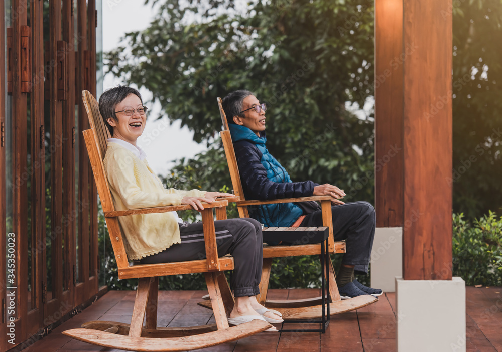 A happy old couple resting on the balcony in a pair of rocking chairs A happy old couple resting on the balcony in a pair of rocking chairs