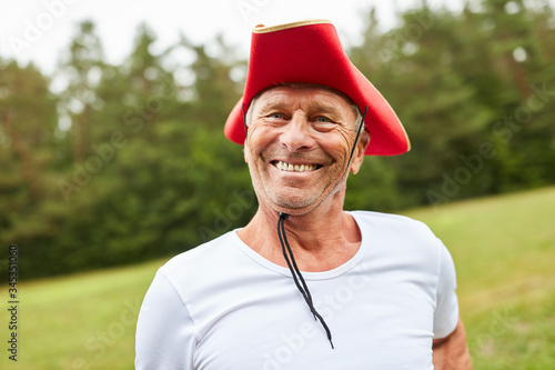 Senior man at carnival with red hat