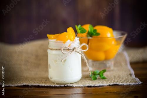 homemade sweet yogurt with slices of pickled peaches in a glass jar