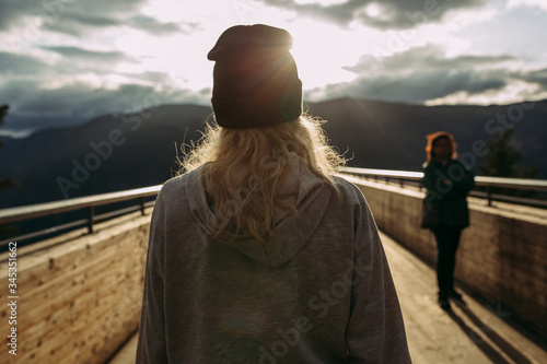 girl stands facing the sun on a bridge in Norway
