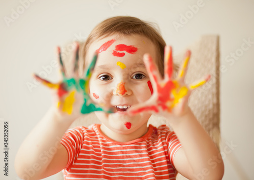 Girl showing painted hands. Hands painted in colorful paints. Education  school  art and painitng concept.