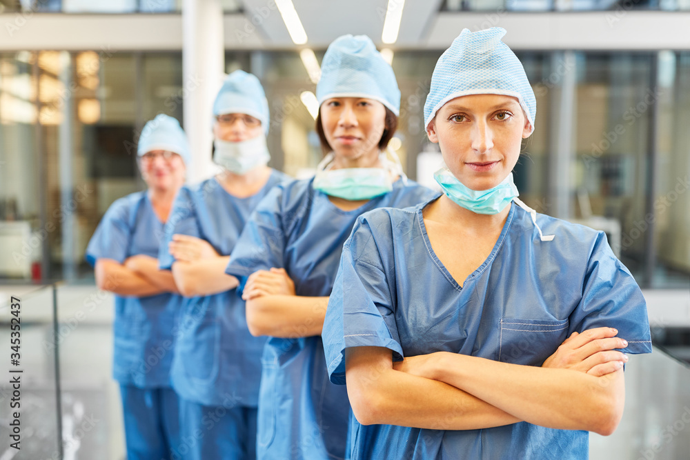 Surgeon with crossed arms in front of her team Surgeon with crossed arms in front of her team